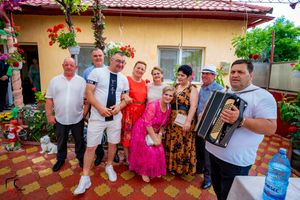 People celebrating at an outdoor gathering with colorful flowers and decorative tiles.