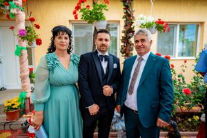 Formal gathering on decorative tiled patio with hanging plants and red flowers.