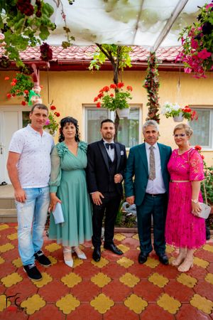 Mixed casual and formal gathering on patterned tile patio with floral decorations.
