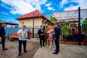 Wide shot of wedding guests gathered at an outdoor venue under bright blue skies.