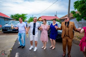 Guests participate in a line dance at an outdoor wedding celebration.