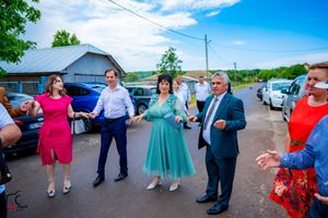 Outdoor celebration with guests in formal attire dancing on a sunny day.