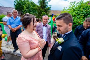Wedding guests interact during an outdoor reception on a sunny afternoon.