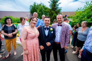 Wedding celebration with guests in formal wear enjoying an outdoor reception.