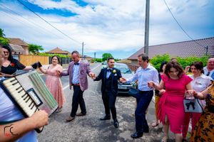 Panoramic view of wedding guests socializing outside a building with distinctive architecture.