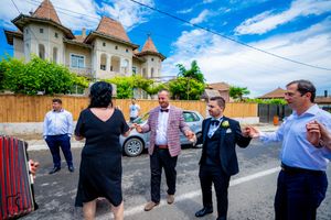 Wedding celebration outside a building with turrets under bright blue summer skies.