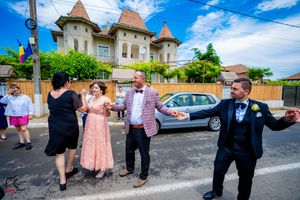 Guests mingle during an outdoor wedding reception near a distinctive turreted building.