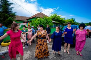 Dancers forming a long line at an outdoor party under blue skies.