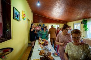 Indoor celebration with yellow walls and wooden ceiling decorated for a special occasion.