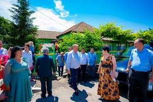 Guests chatting at an outdoor social event under bright blue skies.