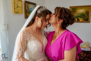 An intimate wedding day moment showing two people embracing in a room with decorative wall art.