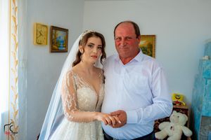 A wedding day portrait showing a bride and another person standing together in a decorated room.