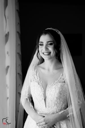 Black and white candid bridal portrait showing detailed lace gown and crystal headpiece.