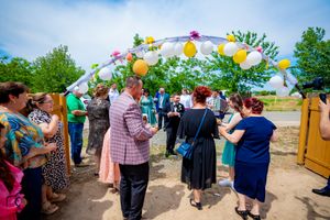 Outdoor wedding celebration with colorful balloons and decorative arch setup.