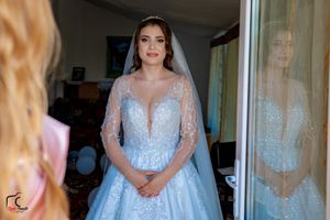 A stunning pale blue bridal gown with sheer details and beading is featured.