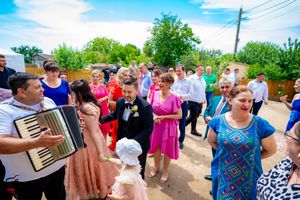 Wedding guests gather outdoors for a celebration under blue skies.