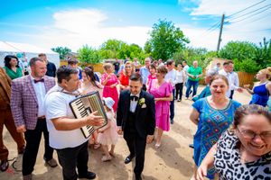 Guests enjoy a lively outdoor wedding reception on a sunny afternoon.