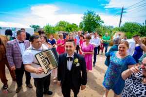 Wedding attendees celebrate at an outdoor reception with musicians.