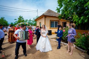 Outdoor wedding celebration with guests gathered on sunny day at rustic venue.