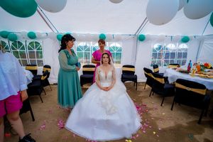 Wedding reception tent decorated with teal and white balloons and elegant table settings.