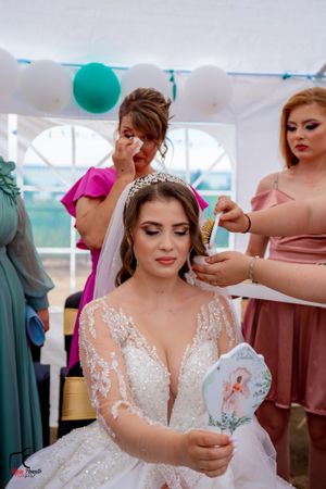 Wedding celebration showing elegant white lace dress details under decorated tent.