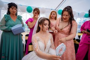Wedding celebration showing attendees in colorful dresses socializing during an outdoor tented reception.