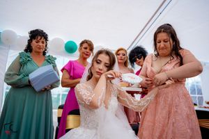 Group of wedding attendees in pastel and jewel-toned dresses sharing a moment together.