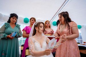 Wedding party members in pink and teal dresses interact during reception festivities.