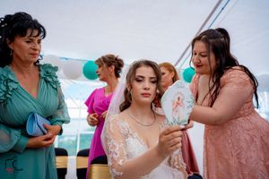 Wedding party members in coordinated dresses gather during outdoor reception.