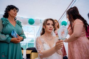 Wedding party members in pink and teal dresses celebrate during outdoor reception.