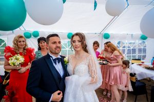 Wedding celebration scene with teal and white balloons decorating an elegant indoor venue.