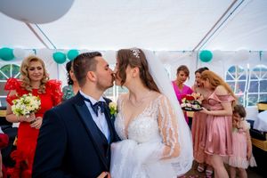 Elegant wedding reception with teal balloon decor and guests in formal attire.