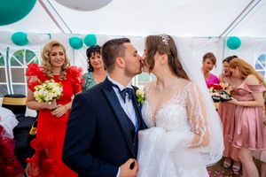 Wedding celebration showing decorative teal balloons and guests in formal wear.