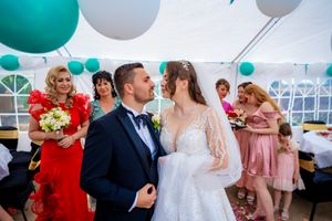 Wedding reception scene with teal balloon decorations and guests mingling.