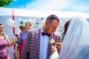 Candid moments from outdoor wedding celebration under white tent with blue sky backdrop.