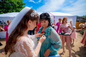 Intimate conversation between wedding guests during outdoor celebration under white tent.
