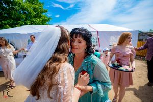 Close interaction between wedding attendees during sunny outdoor celebration.