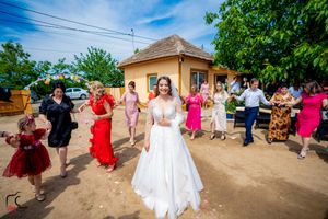 Outdoor wedding celebration with guests dancing in formation under bright blue skies.