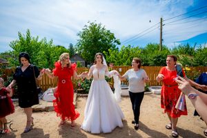 Wedding party performs choreographed dance routine on sunny outdoor patio.
