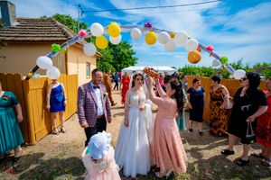 Celebration in a backyard with decorative balloons and streamers under clear blue skies.