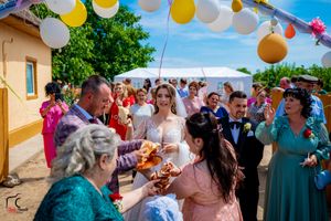 Outdoor wedding celebration with colorful balloon decorations and guests participating in traditional customs.