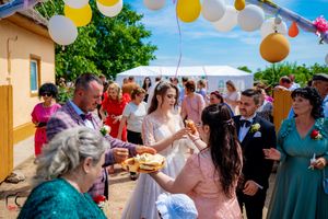 Wedding celebration with guests gathered under balloon arch during traditional ceremonial customs.