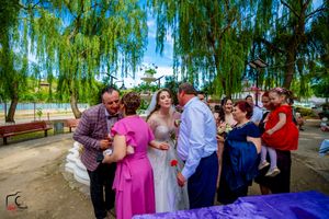 Wedding party members gather for photos under a majestic weeping willow.