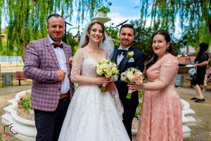 Wedding party members sharing drinks and smiles during outdoor celebration.