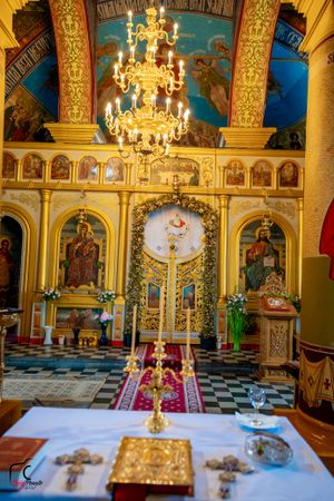 Ornate Orthodox church interior with golden decorations and crystal chandeliers.