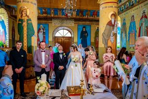 Traditional Orthodox church ceremony with decorated interior and religious iconography.