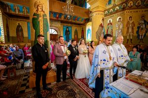 Orthodox Christian marriage ceremony with attendees gathered in a beautifully decorated sanctuary.