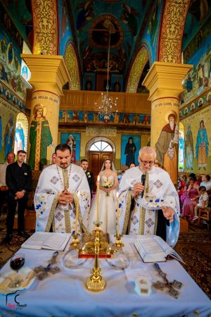 Orthodox priests conducting wedding ceremony at altar table with sacred vessels and religious items.