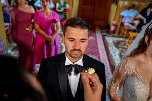 Wedding ceremony in progress at an Orthodox church with decorative interior.