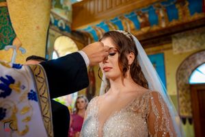 Intimate wedding moment captured in an Orthodox church with beautiful iconographic artwork.